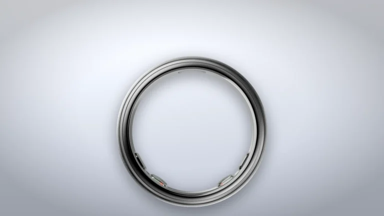 Oura Ring 5 in Brushed Silver seen from the side on a plain studio background, with three sensor domes visible on the inner surface