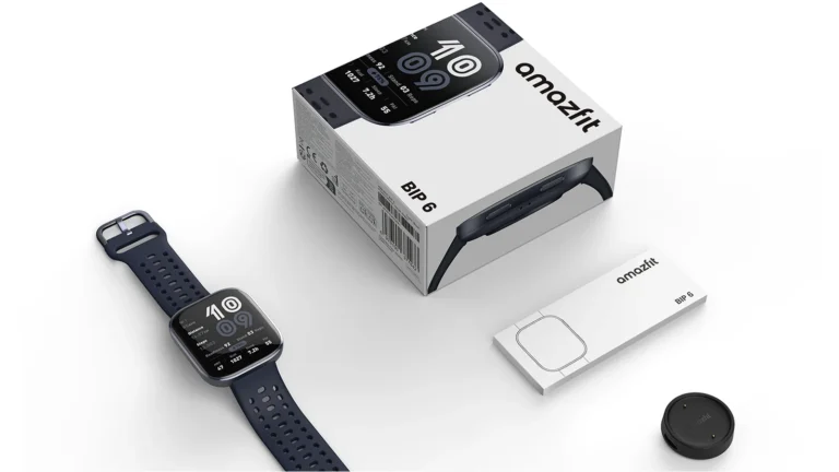 Amazfit Bip 6 in Black lying beside its retail box, a small instruction card and the round magnetic charging puck