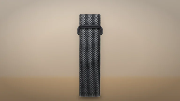 Fitbit Air Obsidian band laid out flat and upright, showing its woven strap and buckle, against a warm beige background